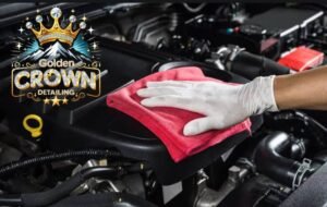 Wiping down an engine bay during an engine bay detail