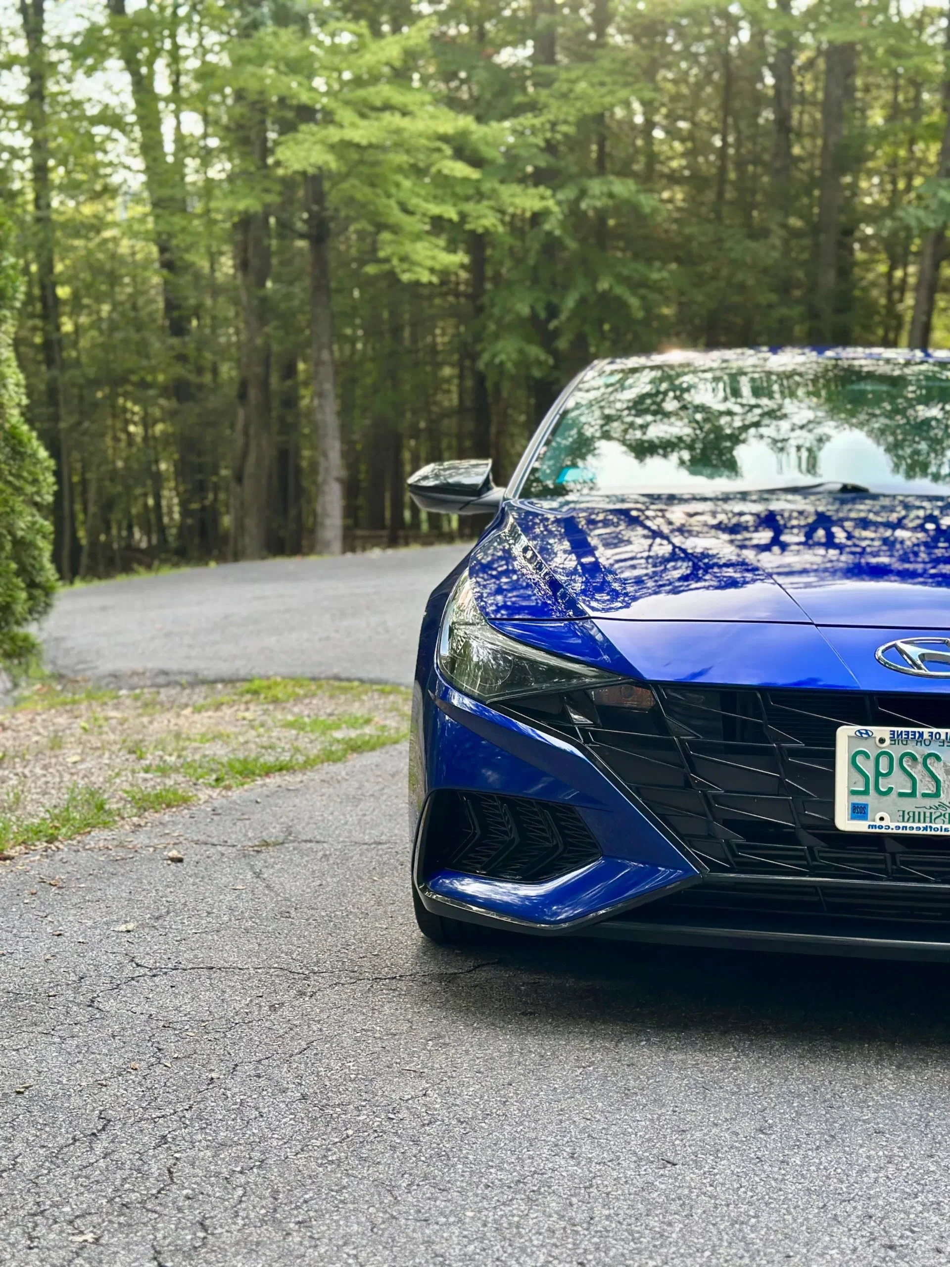 Blue sedan after a full detail in a customer's driveway