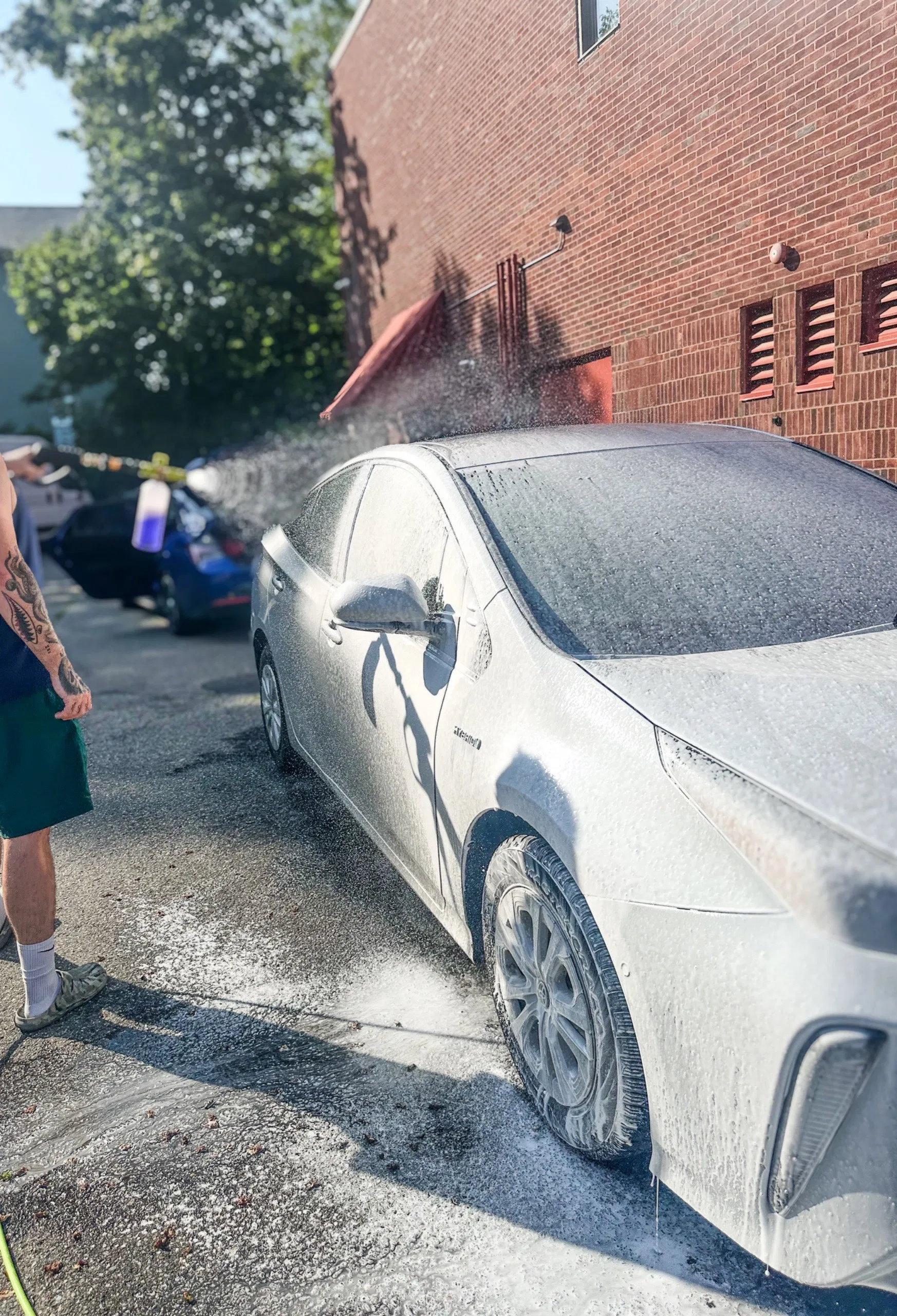 Rinsing a white car during a mobile wash