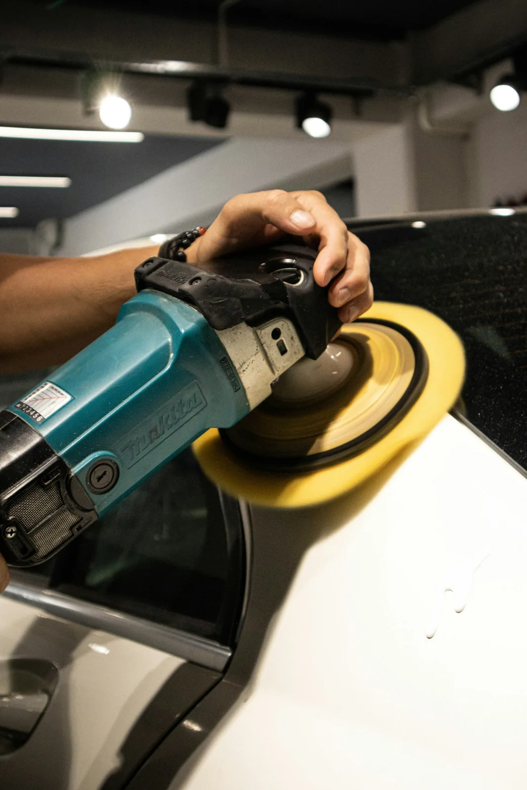 Rotary polisher with a foam pad correcting car paint
